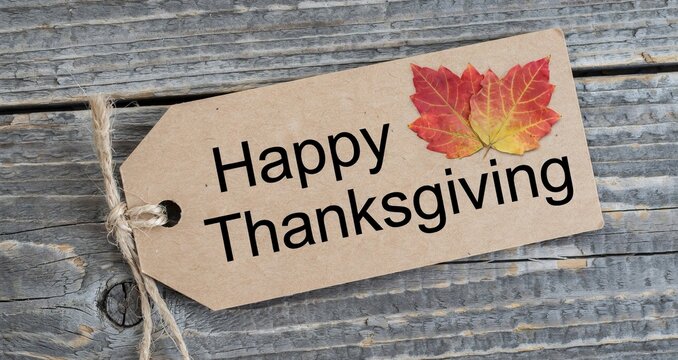 Happy thanksgiving tag with autumn leaves on weathered gray wood
