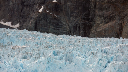 Fototapeta premium Breathtaking and impressive panoramic view of Margerie glacier in Glacier Bay Fjord, enframed by mountain vegetation and green trees during summer Last Frontier fjord cruising