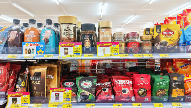 A vibrant display of various coffee brands and products, including instant coffee, ground coffee, and coffee mixes, Shelves of coffee products including Nescafe and Moccona. Thailand, June 19, 2026