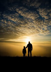 Fototapeta premium Silhouette of Father and Son Standing on a Hilltop Watching the Golden Sunset Above the Clouds