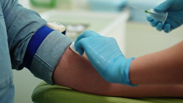 Close-up of a healthcare professional drawing blood from a patient's arm using a syringe during a routine blood test.