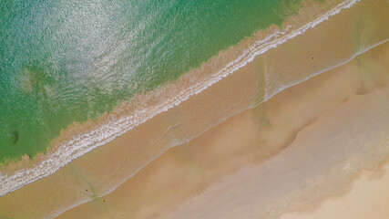 Aerial view of waves rolling onto a beach at Cape Northumberland, South Australia, with textured ocean patterns and foamy lines meeting the shoreline, capturing the raw, windswept beauty of Australia’ © Niki