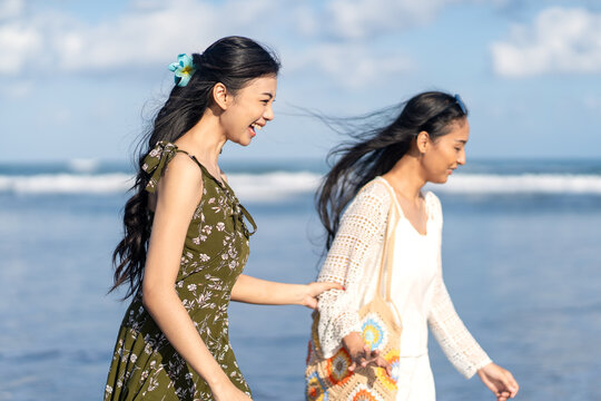Young Asian Women Walking Along Ocean Shore at Parangtritis Beach