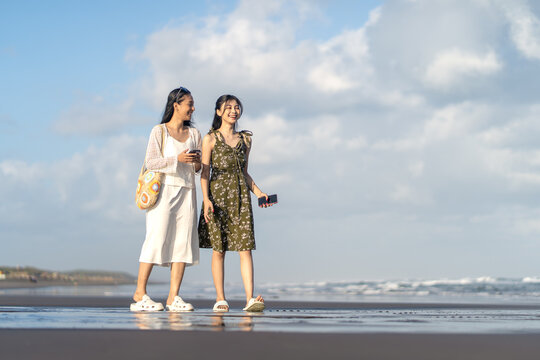 Young Women Exploring Parangtritis Beach With Smartphone