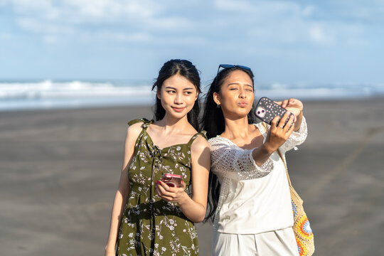 Two Asian Women Taking Selfie on Parangtritis Beach Yogyakarta