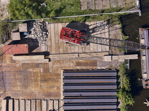 Wormerveer, Netherlands - 28 April 2026: Aerial view of a sheet piling rig crane and sheet pile storage at the Meneba flourmill silo site during the Zaankwartier redevelopment project.