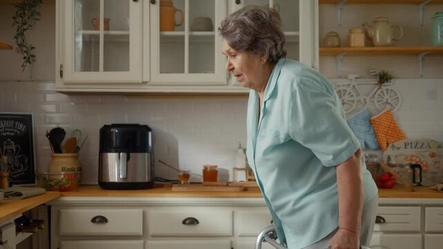 Caregiver supports a smiling senior woman walking with a walker at home, reflecting compassionate care, mobility assistance and independent living.
