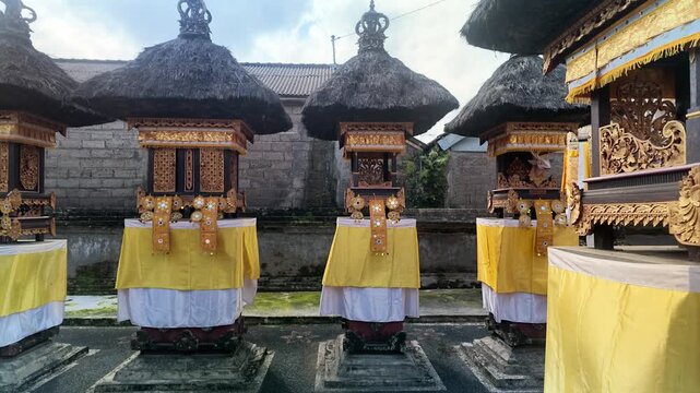 Traditional Balinese Hindu House Temple Shrines with Thatch Roofs and Yellow Cloth