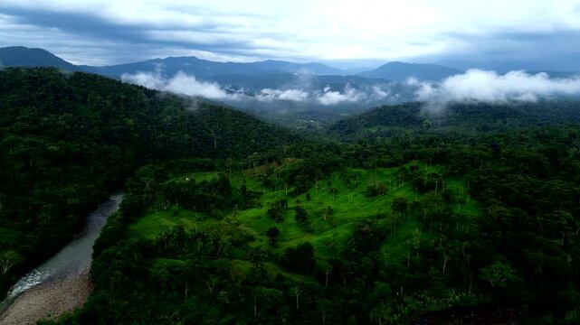 Drone View of Misty Tropical River Valley in Ecuador, Green Forest Hills, Low Clouds, Remote Rainforest Wilderness and Andean Amazon Landscape