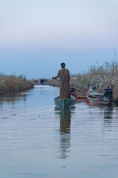 An Iraqi Marsh Arab known as The Ma&rsquo;dan poles his canoe known as a Mashoof through the waters of The Southern Marshes of Iraq, a wetland under threat from climate change, Middle East. 