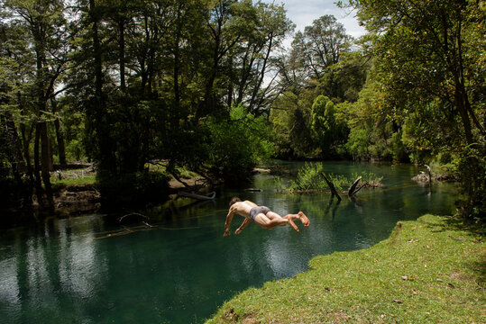 Man diving headfirst into a green river