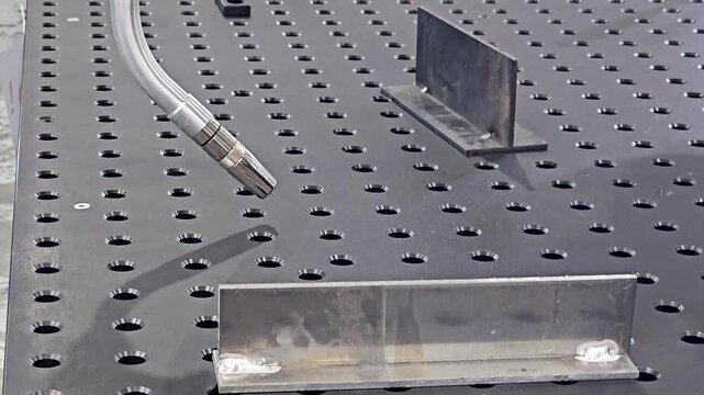 Robotic Welding Arm Performing Automated Dry Run Movement on Perforated Welding Table