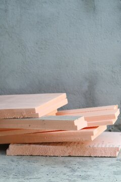 Cut pieces of orange XPS extruded polystyrene foam boards near a concrete wall