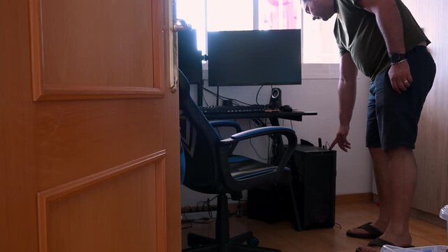 Man turning on a gaming computer with rgb lights