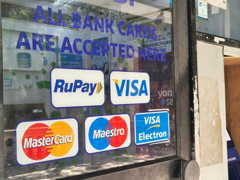 Payment card acceptance signage displaying RuPay, Visa, Mastercard and Maestro networks at an ATM. Digital payments, UPI, banking, cash access, electronic transactions, profit and loss trends growths