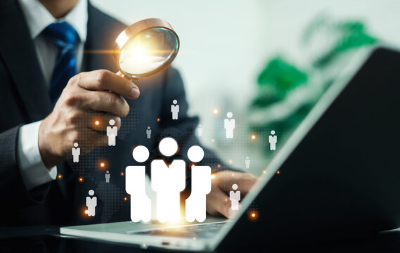 Business recruitment and talent acquisition concept featuring a professional using a magnifying glass to identify qualified candidates on a digital network. Human resources, hiring workforce analytics