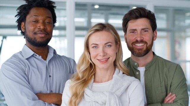 Business team smiling happy at workplace three multiethnic adults business people crossing arms pose smile carefree cooperation African businessmen Caucasian businesswoman crossed hands in office