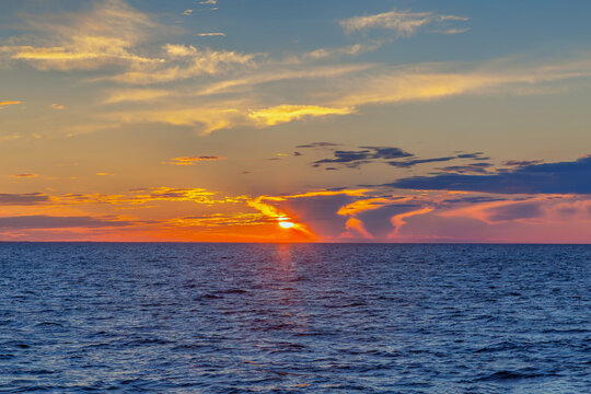 Dramatic sunset over Ladoga lake in Russia. Wide angle view of red sky with clouds in summer