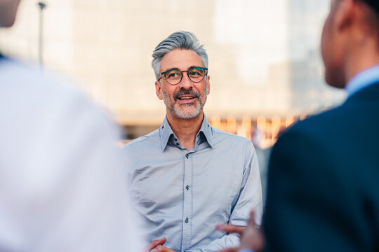 Professional man discussing business with colleagues outdoors