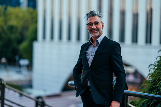 Confident businessman standing urban outdoor looking camera