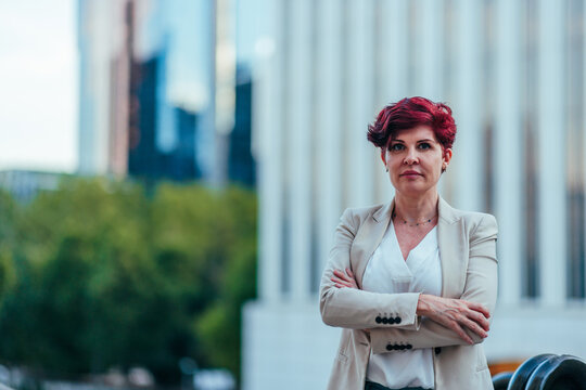 Businesswoman with red hair standing confident in city
