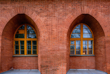 Fototapeta premium A brick wall with large arched windows.