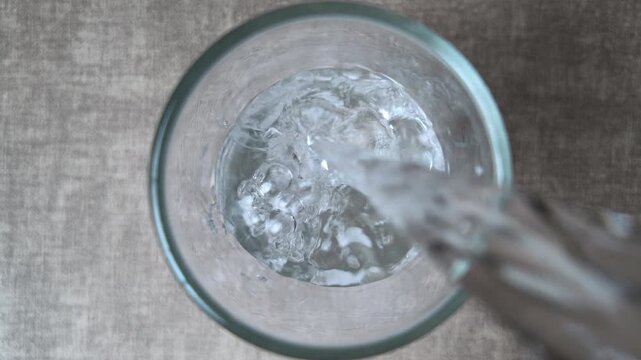 Fresh Drinking Water Pouring into Glass Top View Hydration Concept