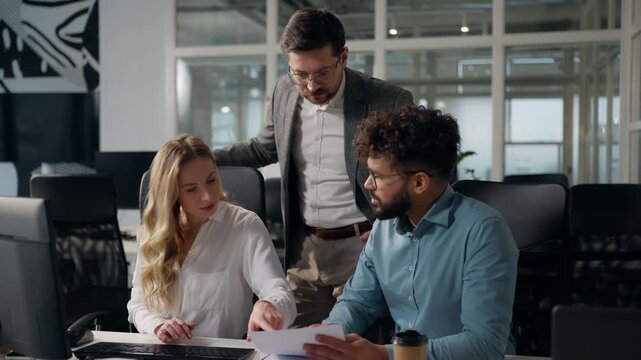 Three multiethnic office managers reviewing papers talking arguing business team group multiracial businesswoman talk with businessmen documents analyzing work report talk cooperation argue in office