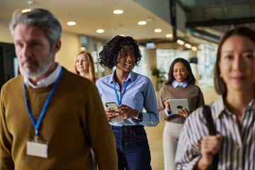 Diverse business professionals walking in modern office corridor