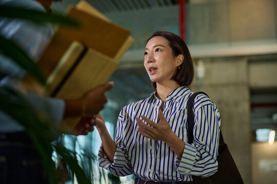 Asian businesswoman discussing project with colleague in office