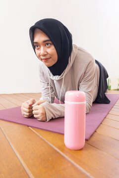 Young jilbab women is exercise at home with tumbler