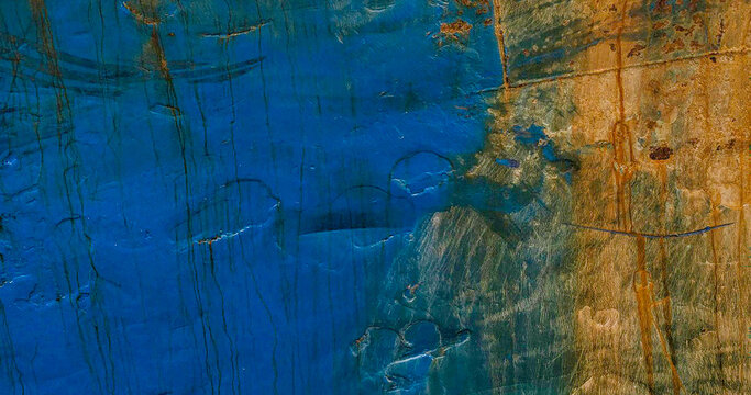 Weathered blue paint and rust texture on an old ship hull.