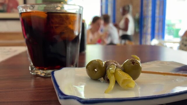 Traditional Spanish tapas at a bar with some people in the background.