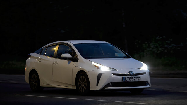 Milton Keynes,Bucks,UK - Apr 29th 2026:  2019 white Toyota Prius hybrid electric car driving at night on a British road