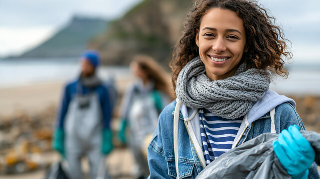 Young volunteer smiling while holding a bag after a beach cleanup with practical field equipment, safety-focused workflow and believable environmental context, highlighting climate action,