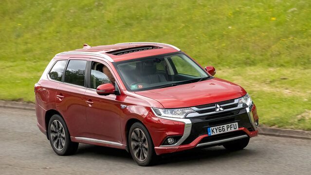 Milton Keynes,Bucks,UK - June 17th 2026: 2016 red Mitsubishi Outlander hybrid electric SUV car driving on a British road