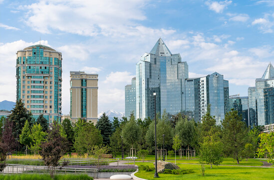Modern Nurly Tau business district skyline in Almaty viewed from former presidential residence park on Nazarbayev avenue under blue summer sky
