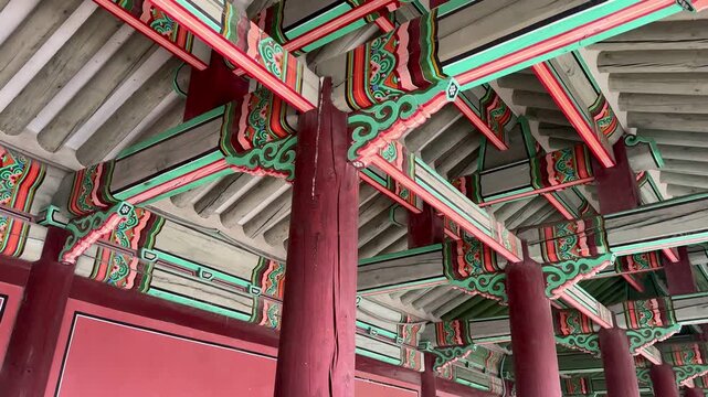Crafted palace building featuring traditional wooden columns set on stone bases seen at Jinseonmun interior, Changdeokgung Palace.