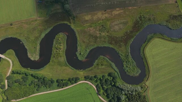 Aerial view of meandering river winding through green landscape
