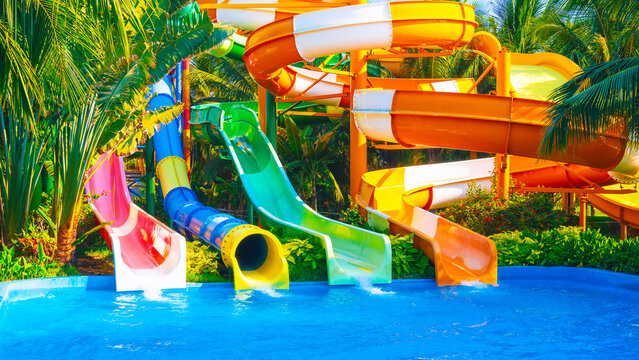 A modern water park with swirling slides and tropical palm trees