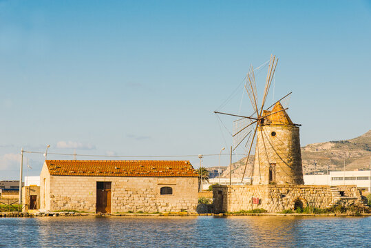 Trapani sea salt production view of old windmill at salt marches in Sicily, Italy.	