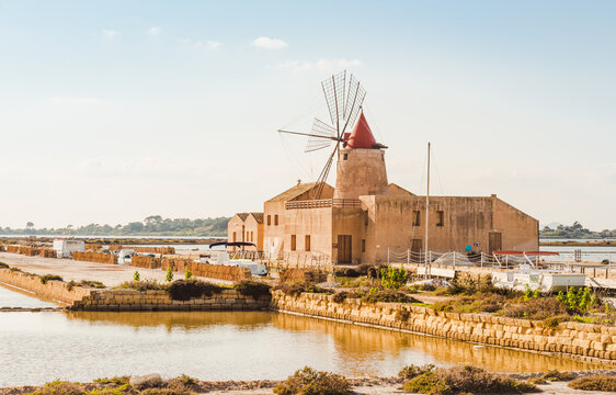 Trapani sea salt production view of old windmill at salt marches in Sicily, Italy.	