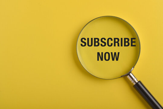 Magnifying glass highlighting subscribe now message on yellow background. Concept of subscription services, digital marketing, customer engagement, membership signup, and promotional call to action.