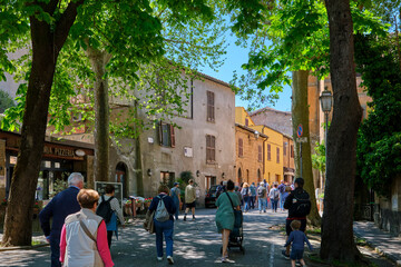 Obraz premium Charming street view in the medieval city of Orvieto, Umbria, Italy, featuring historic stone buildings, cobblestone roads, traditional architecture, and a peaceful atmosphere under a clear blue sky.