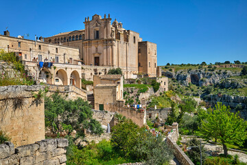 Obraz premium street view in the medieval city of Matera, Basilicata, Italy, featuring historic stone buildings, ancient architecture, under a clear blue sky in the UNESCO World Heritage 