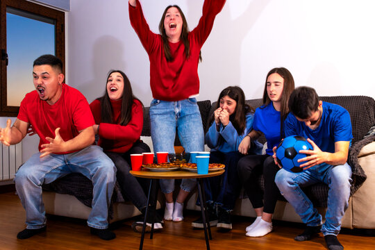 People with different emotions watching soccer at home, enjoying snacks and drinks during a game