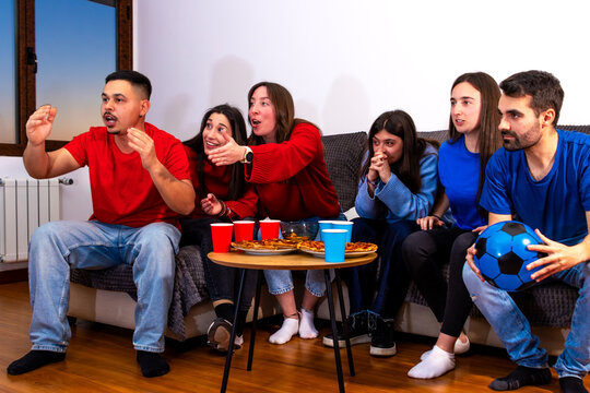 Friends watching a football match together at home, celebrating goals and emotions