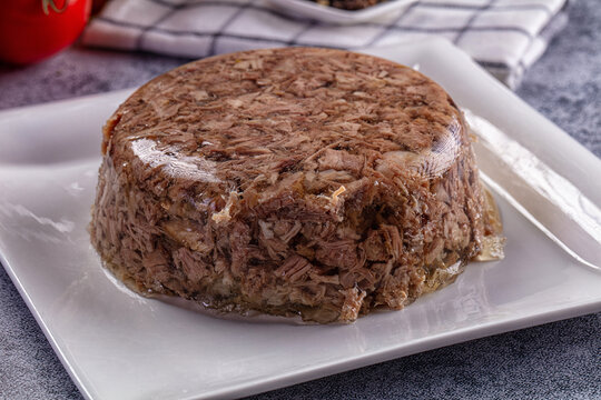 Round beef aspic on white plate