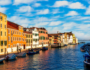 Obraz premium city of Venice with beautiful old buildings near embarkment of a canal wirh boats and water and beautiful cloudy sky on background