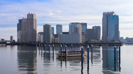 ウォーターフロントのマンション群と水面に浮かぶ屋形船  © 茂明 北村